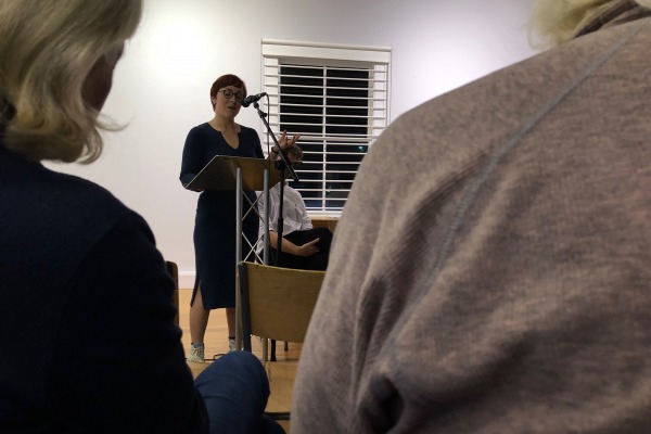 Ramona Herdman reads at a lectern in the Peter Pears Gallery