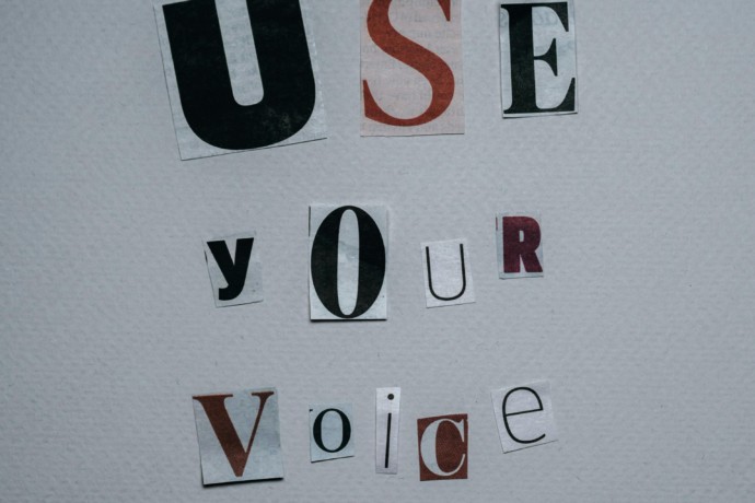 Letters cut out of magazines to form the sentence 'use your voice' to make a change and fight injustice